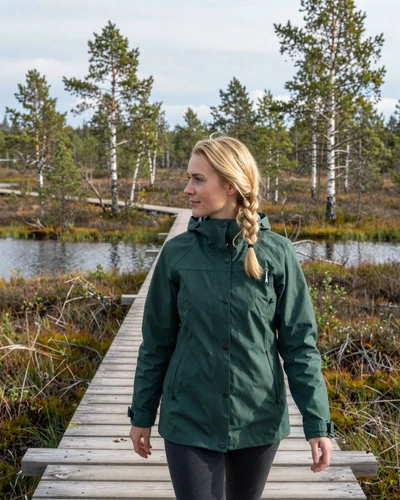 Estonian woman walking through bog landscape on wooden boardwalk in natural setting