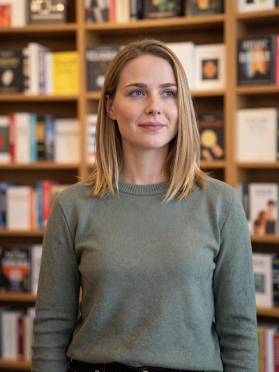 Hannah, 30, German woman with blonde hair in a cozy Berlin bookshop