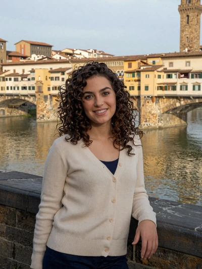 Chiara, 26, Italian woman with curly dark hair overlooking the Arno in Florence